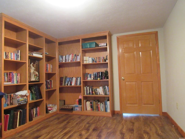 miscellaneous room with a textured ceiling and dark hardwood / wood-style flooring