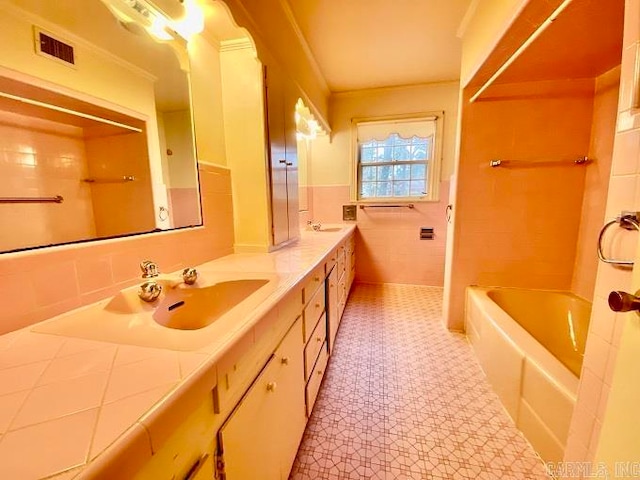 bathroom with oversized vanity, tasteful backsplash, dual sinks, tile walls, and tile flooring