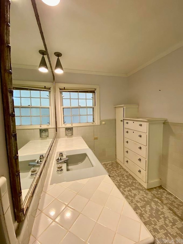 bathroom featuring tile walls, crown molding, tile floors, and sink