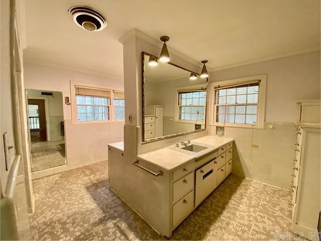 bathroom featuring plenty of natural light, tile flooring, vanity with extensive cabinet space, and ornamental molding