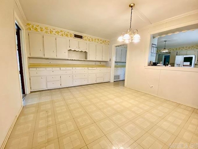 kitchen featuring a notable chandelier, hanging light fixtures, white refrigerator with ice dispenser, and light tile flooring