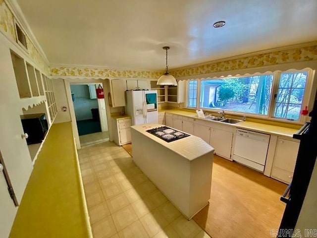 kitchen with pendant lighting, light wood-type flooring, white appliances, sink, and white cabinetry