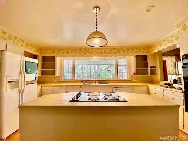 kitchen featuring a center island, white cabinetry, white refrigerator with ice dispenser, hanging light fixtures, and sink