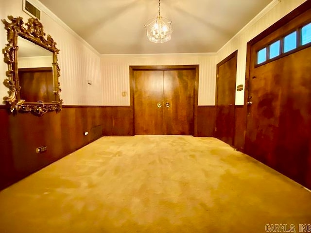 unfurnished bedroom featuring a chandelier, ornamental molding, and a closet