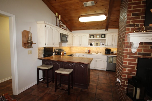 kitchen with backsplash, vaulted ceiling, wood ceiling, and appliances with stainless steel finishes