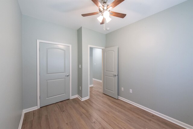 unfurnished bedroom with ceiling fan and light hardwood / wood-style flooring