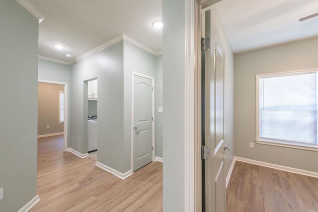 corridor featuring crown molding and light hardwood / wood-style flooring