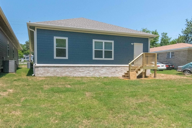 back of house with a yard and central AC unit