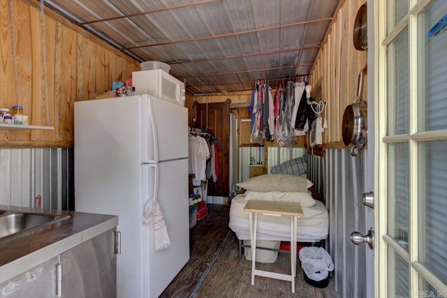 interior space featuring wood walls and white refrigerator