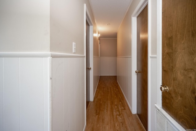 hall with light hardwood / wood-style flooring and a textured ceiling