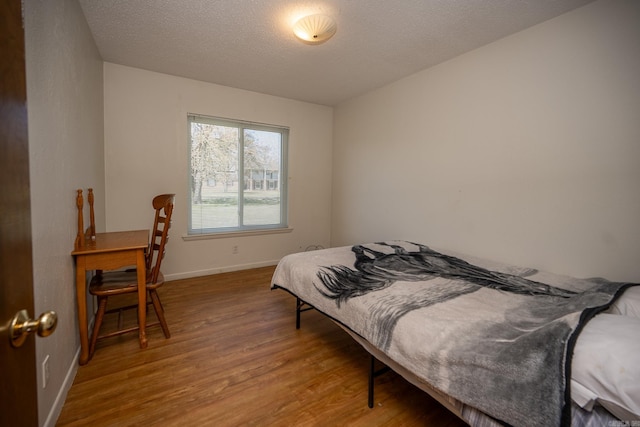 bedroom featuring a textured ceiling and light wood-type flooring