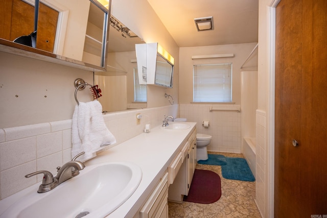 full bathroom featuring tile walls, toilet, dual bowl vanity, tile floors, and tasteful backsplash