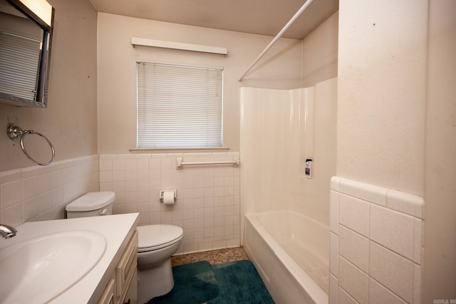 full bathroom with tile walls, toilet, vanity, and bathtub / shower combination