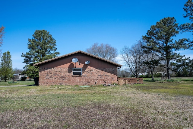 view of side of home with a wooden deck and a yard