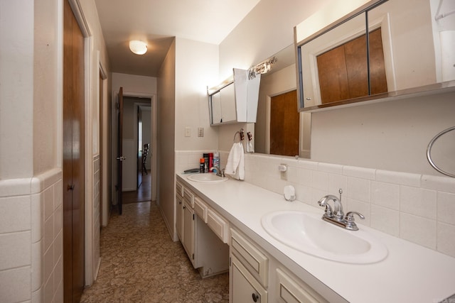 bathroom with backsplash, dual sinks, vanity with extensive cabinet space, and tile flooring