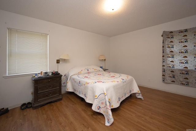 bedroom with dark hardwood / wood-style flooring