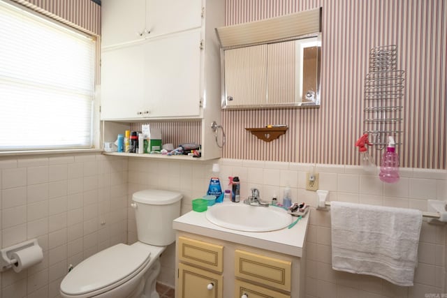 bathroom featuring tile walls, backsplash, toilet, and vanity