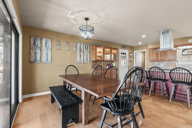 dining space featuring an inviting chandelier and light hardwood / wood-style floors