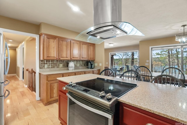 kitchen with light hardwood / wood-style floors, decorative light fixtures, range with electric cooktop, tasteful backsplash, and island exhaust hood