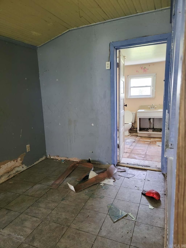 unfurnished room with lofted ceiling, wood ceiling, and tile floors