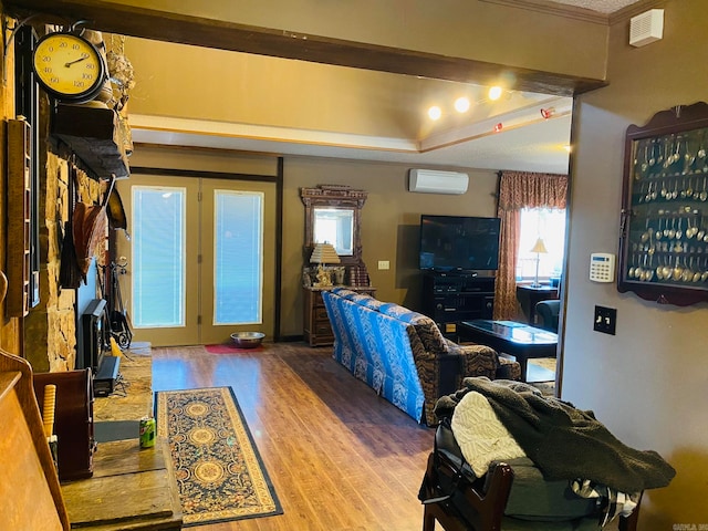 living room with a wall mounted AC, ornamental molding, light wood-type flooring, and french doors