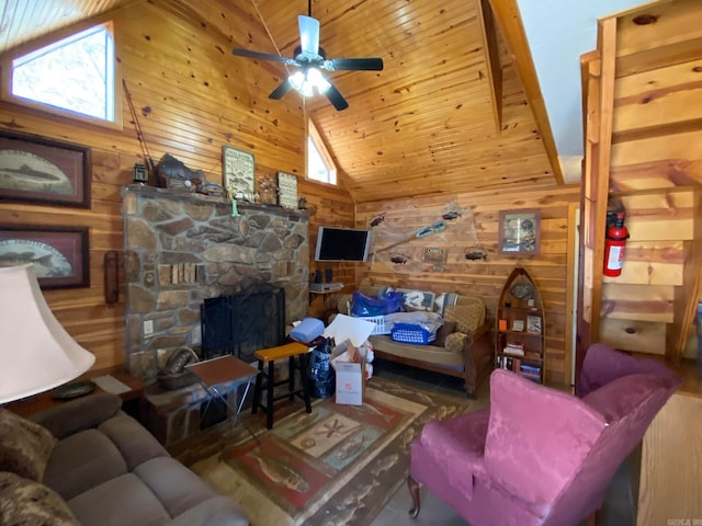 living room with wooden walls, high vaulted ceiling, ceiling fan, and a fireplace