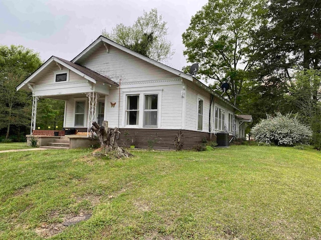 back of house featuring central AC and a yard