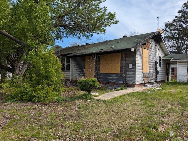 view of side of home with a yard