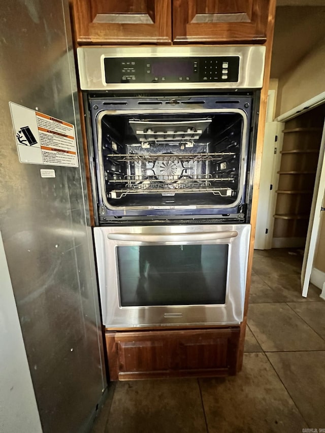 room details featuring double oven and dark tile flooring