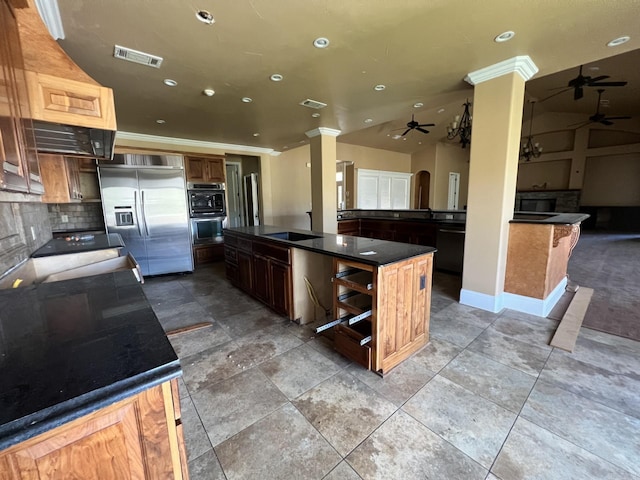 kitchen featuring a kitchen island, ceiling fan, high quality fridge, tasteful backsplash, and decorative columns