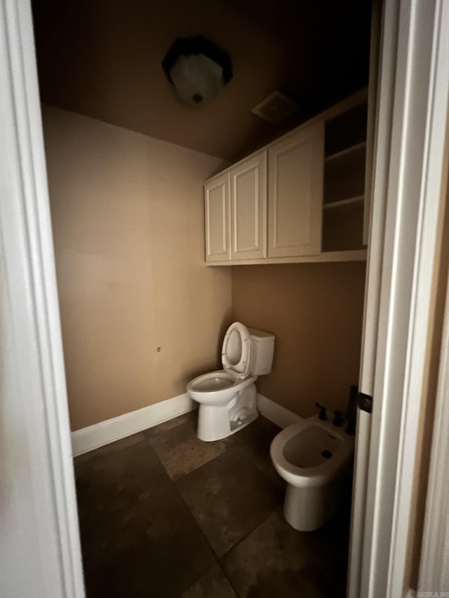 bathroom with a bidet and tile flooring