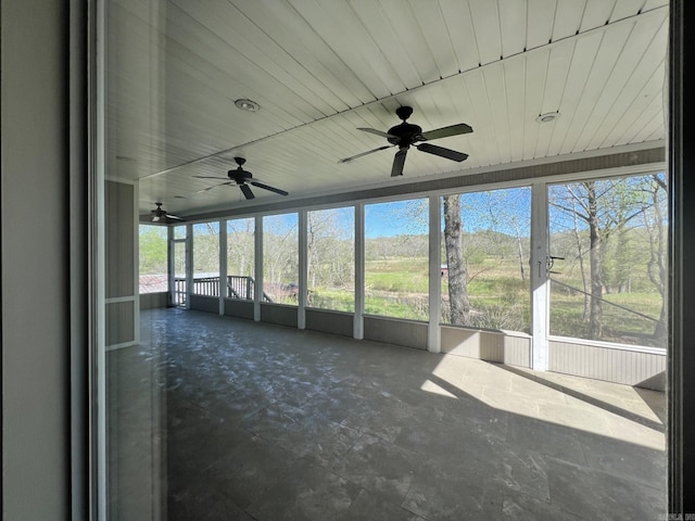 unfurnished sunroom featuring wooden ceiling and ceiling fan