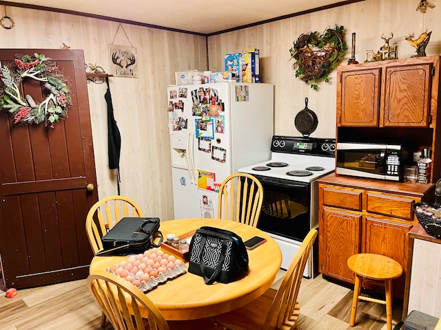 kitchen with wood walls, light hardwood / wood-style flooring, and white appliances