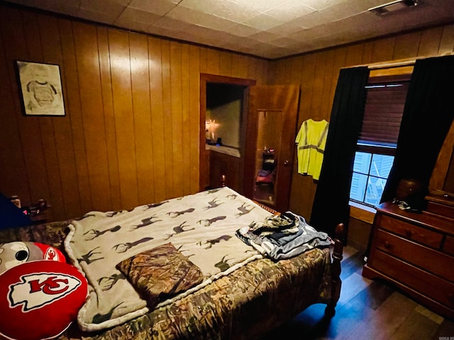 bedroom with wooden walls and wood-type flooring