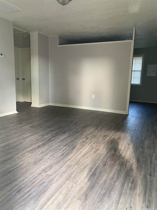 unfurnished room with a textured ceiling and dark hardwood / wood-style floors