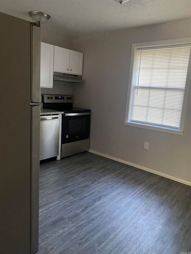 kitchen with appliances with stainless steel finishes, dark hardwood / wood-style floors, and white cabinetry