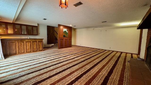 unfurnished living room with light carpet and a textured ceiling