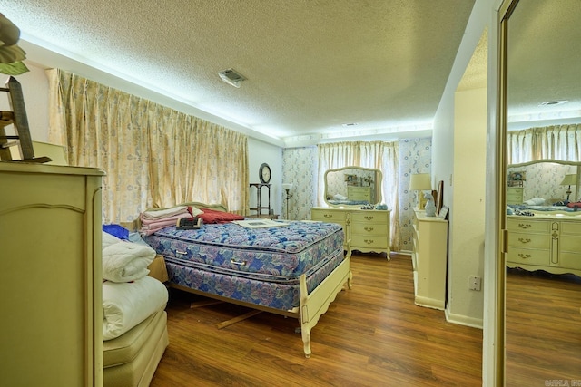 bedroom featuring a textured ceiling and dark hardwood / wood-style flooring