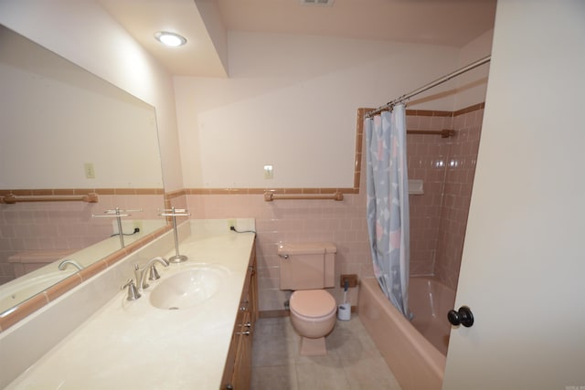 full bathroom featuring toilet, shower / bathtub combination with curtain, vanity with extensive cabinet space, tile walls, and tile floors