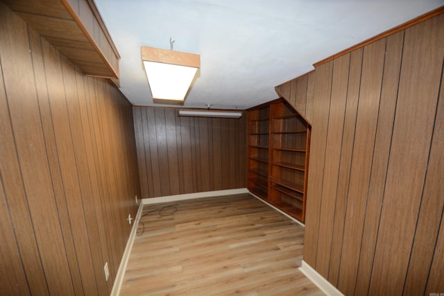 additional living space featuring wooden walls and light hardwood / wood-style flooring