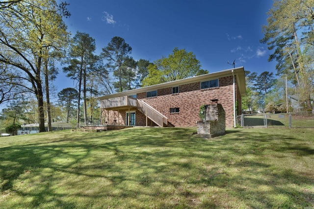 rear view of property featuring a lawn