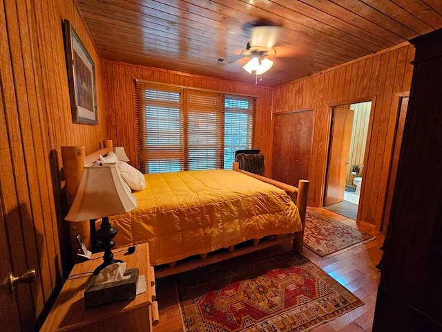 bedroom featuring wooden walls, wood ceiling, ceiling fan, and hardwood / wood-style flooring