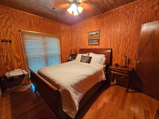 bedroom with wood-type flooring, ceiling fan, wooden walls, and wood ceiling