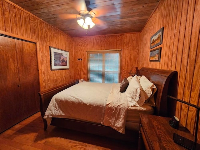 bedroom with wooden ceiling, wood walls, hardwood / wood-style floors, and ceiling fan