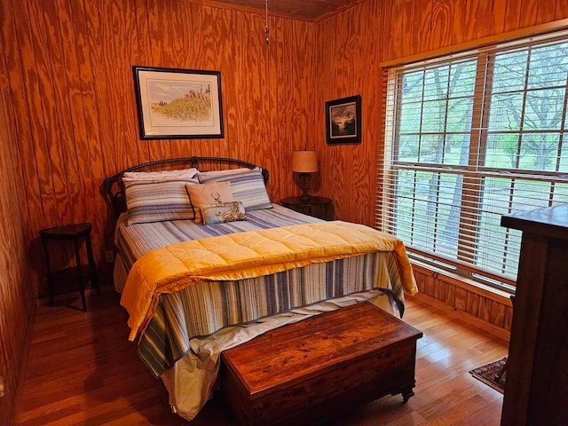 bedroom with wooden walls and hardwood / wood-style floors