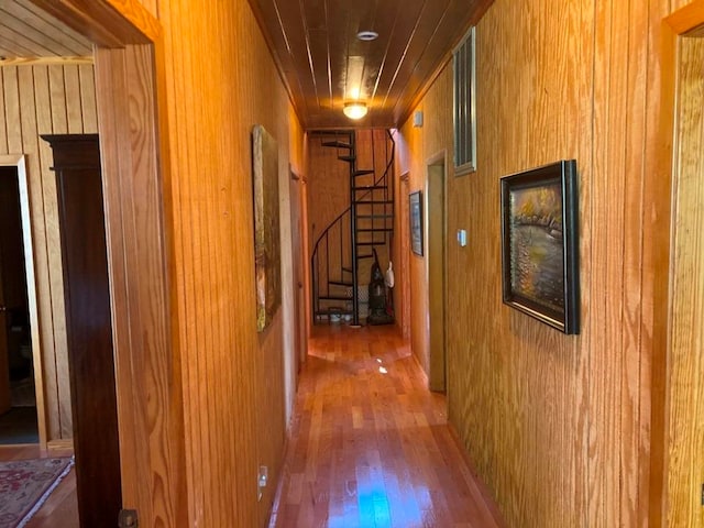 hallway with wood walls and hardwood / wood-style flooring