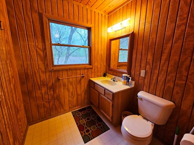 bathroom with wood walls, tile floors, toilet, and oversized vanity