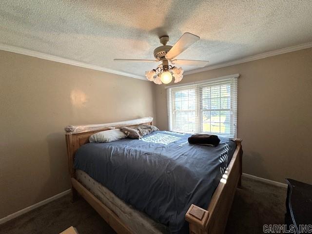 carpeted bedroom featuring ceiling fan, a textured ceiling, and ornamental molding