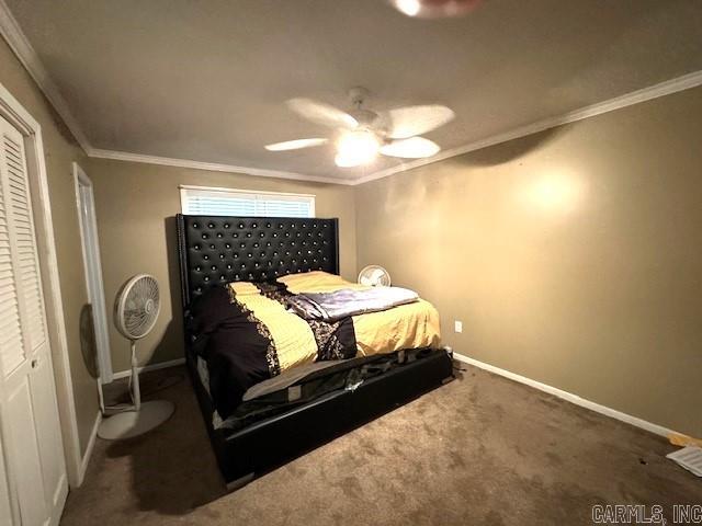 carpeted bedroom with a closet, crown molding, and ceiling fan