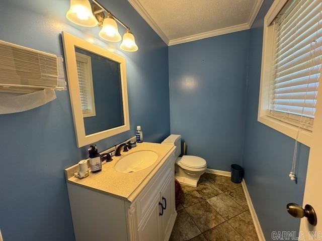 bathroom with vanity, tile floors, a textured ceiling, toilet, and ornamental molding